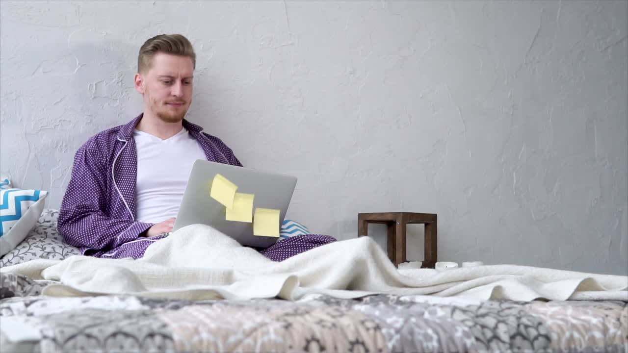 Man Working From Bed in Pajamas
