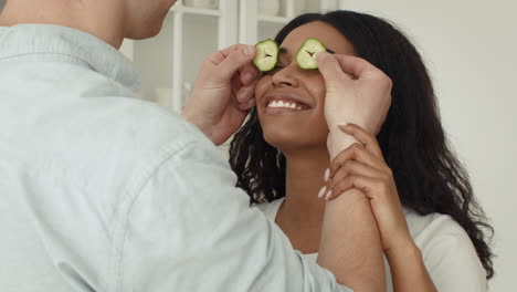 couple playing with cucumber slices
