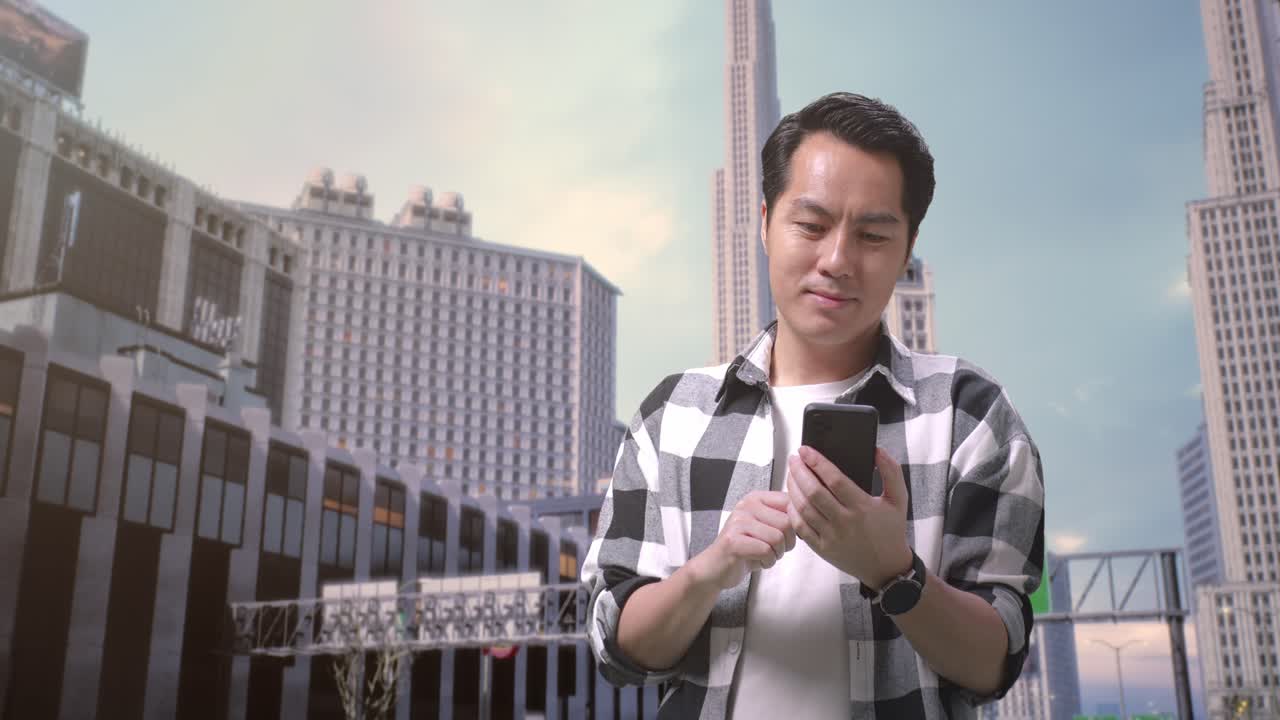 아시아인 프리랜서가 도시에서 일하는 건물 앞에 서서 스마트폰을 사용하고 있습니다.