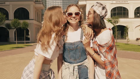 three happy friends having fun in a city park