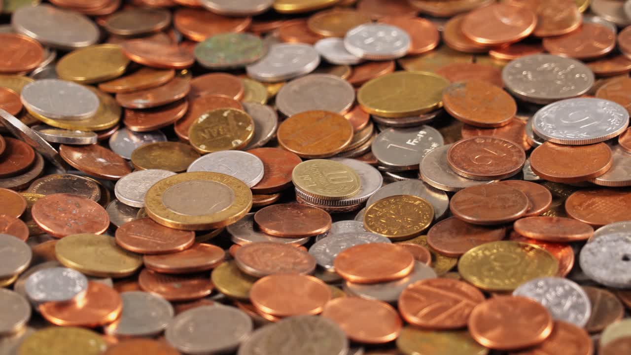 Various coins spread on a surface in different colors and sizes