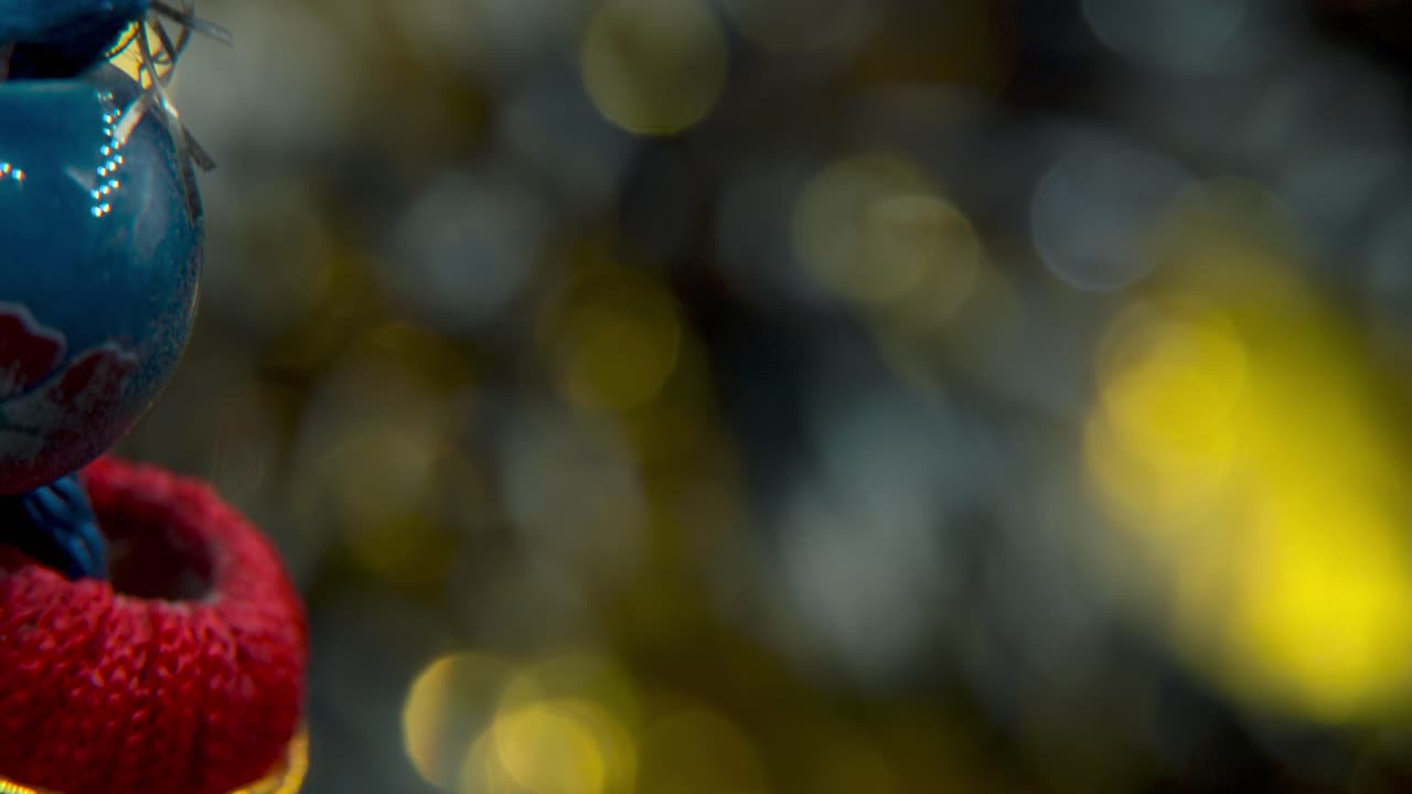 una foto macro de ensueño de una moneda de la suerte tradicional china antigua, decoración de año nuevo asiática de oro, fondo borroso brillante, agujero cuadrado, cuerdas coloridas, día festivo de la cultura, símbolo yin yang, tilt up video 4k