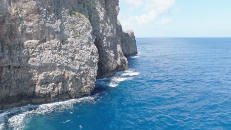 flying close to cliffs rocky surface of cabo cabron national park in samana, dominican republic