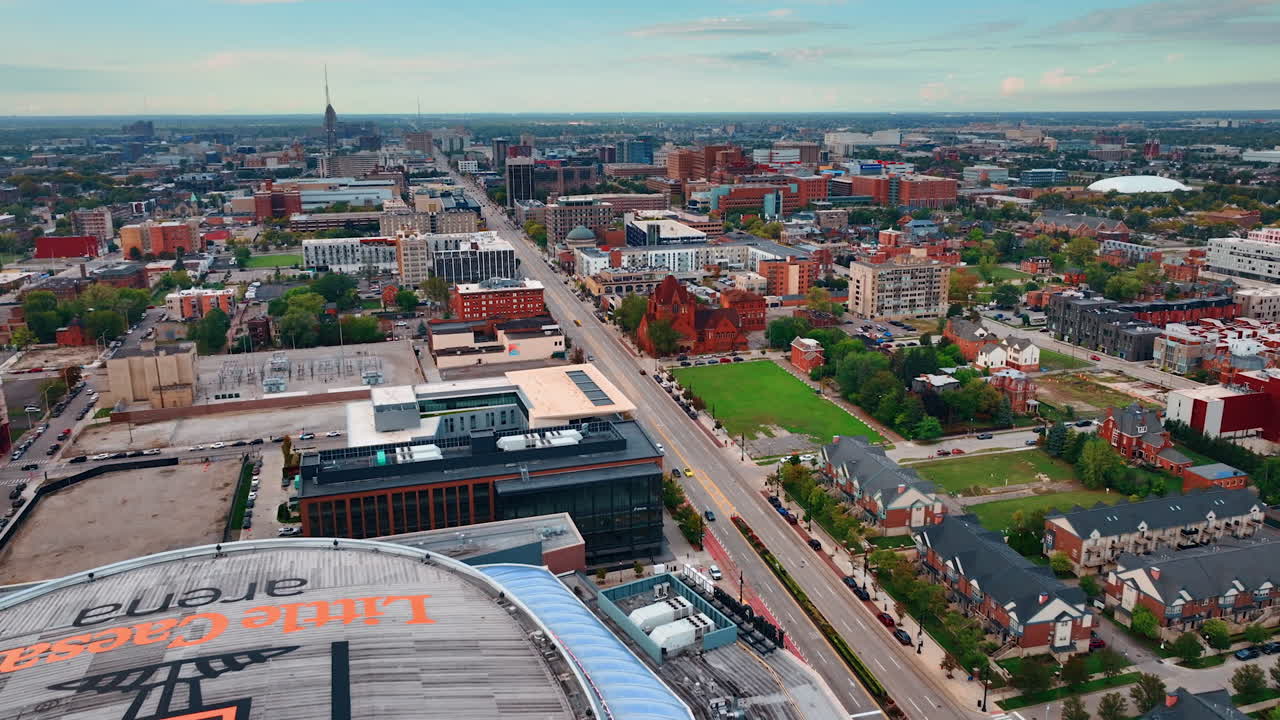 Flying closer to the Little Caesars Arena in the cityscape of Detroit, Michigan, USA. View on the vast urban landscape from drone