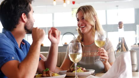 happy young couple interacting while having glass of champagne