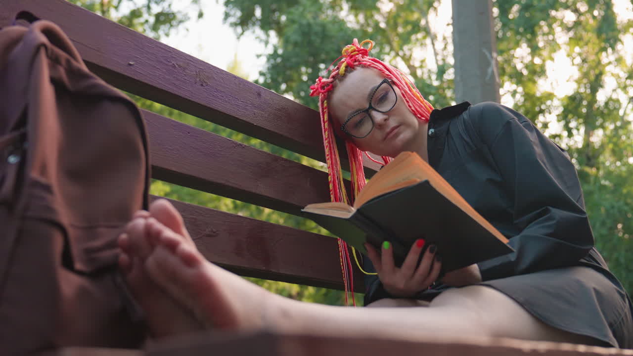 leisurely individual with vibrant braids, casual person resting amidst sunlight and greenery, tranquil moment capturing carefree individual relaxing on bench amid luscious foliage and bright colors