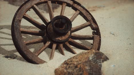 large wooden wheel in the sand