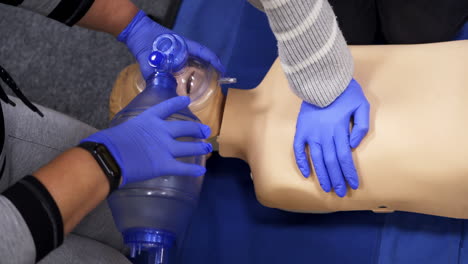medical training session. practitioners doing a compression of heart attack on a dummy for first aid skills.