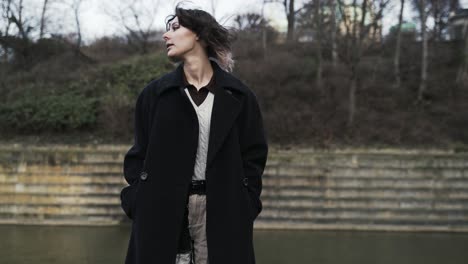 Young-woman-in-a-black-coat-walking-in-a-park-in-autumn-in-afternoon-6