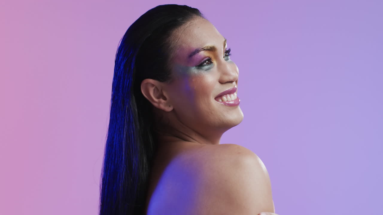 mujer biracial sonriente con cabello negro y maquillaje, copia espacio, cámara lenta