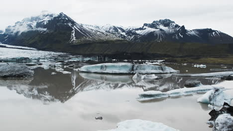 Slow-pan-of-misty-mountain-reflections-on-glacial-lake