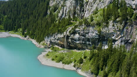 flying up to group of people walking around waterfall in beautiful swiss landscape