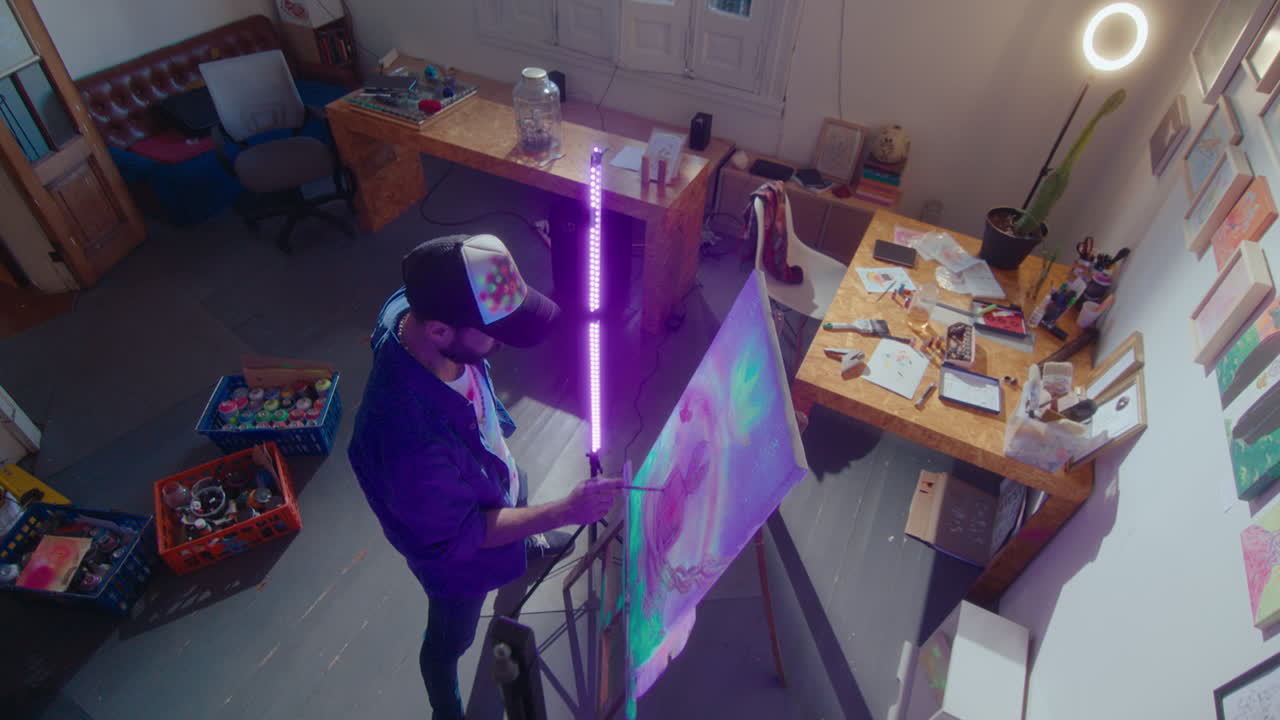 Painter Working with Fluorescent Paint and UV Light in Art Studio