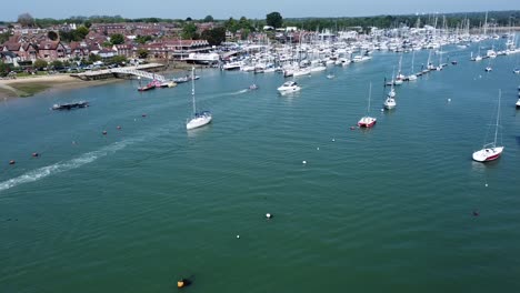 Static-drone-video-of-boats-passing-through-a-large-fishing-port-in-the-south-of-england-on-a-sunny-day