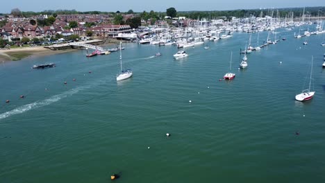 static drone video of boats passing through a large fishing port in the south of england on a sunny day