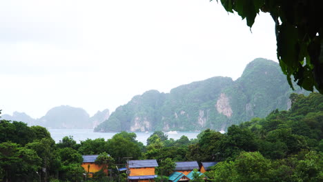 high angle view over treetops of andaman sea and jungle covered mountains, monsoon season rainy weather in koh phi phi, thailand