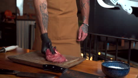 chef butcher hit the cutting board with steak cow boy tattoo arms