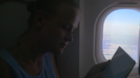 woman with tablet by the plane window