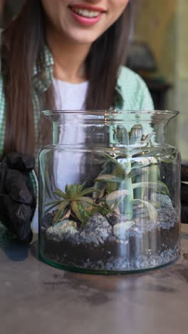 woman caring for succulent terrarium