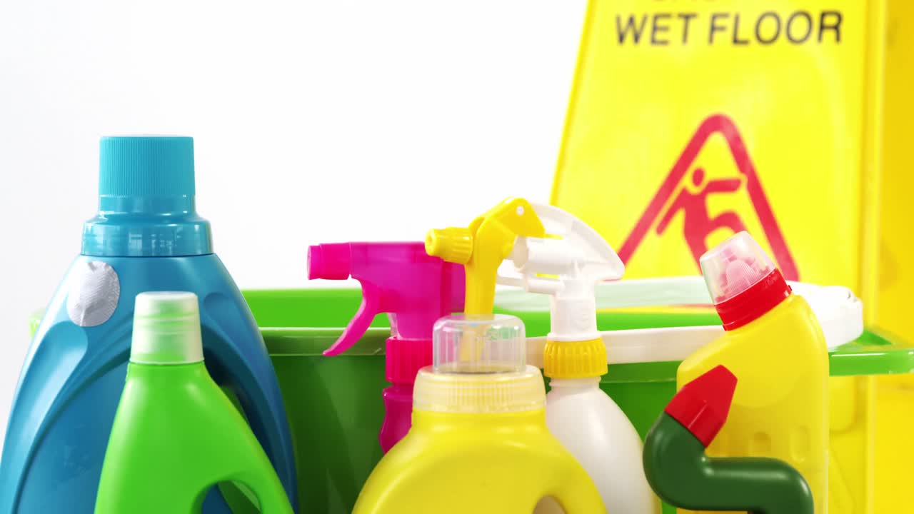 varios suministros de limpieza con un signo de precaución