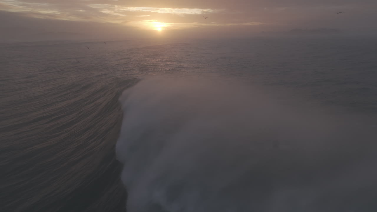 Dramatic Aerial View of a Giant Ocean Wave Crashing at Sunset