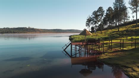 drone flight over a beautiful lake with a pier in misiones, argentina