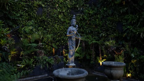 parallax shot of a sacred statue in the cultural park of bali indonesia garuda wisnu kencana overlooking fountain and plants