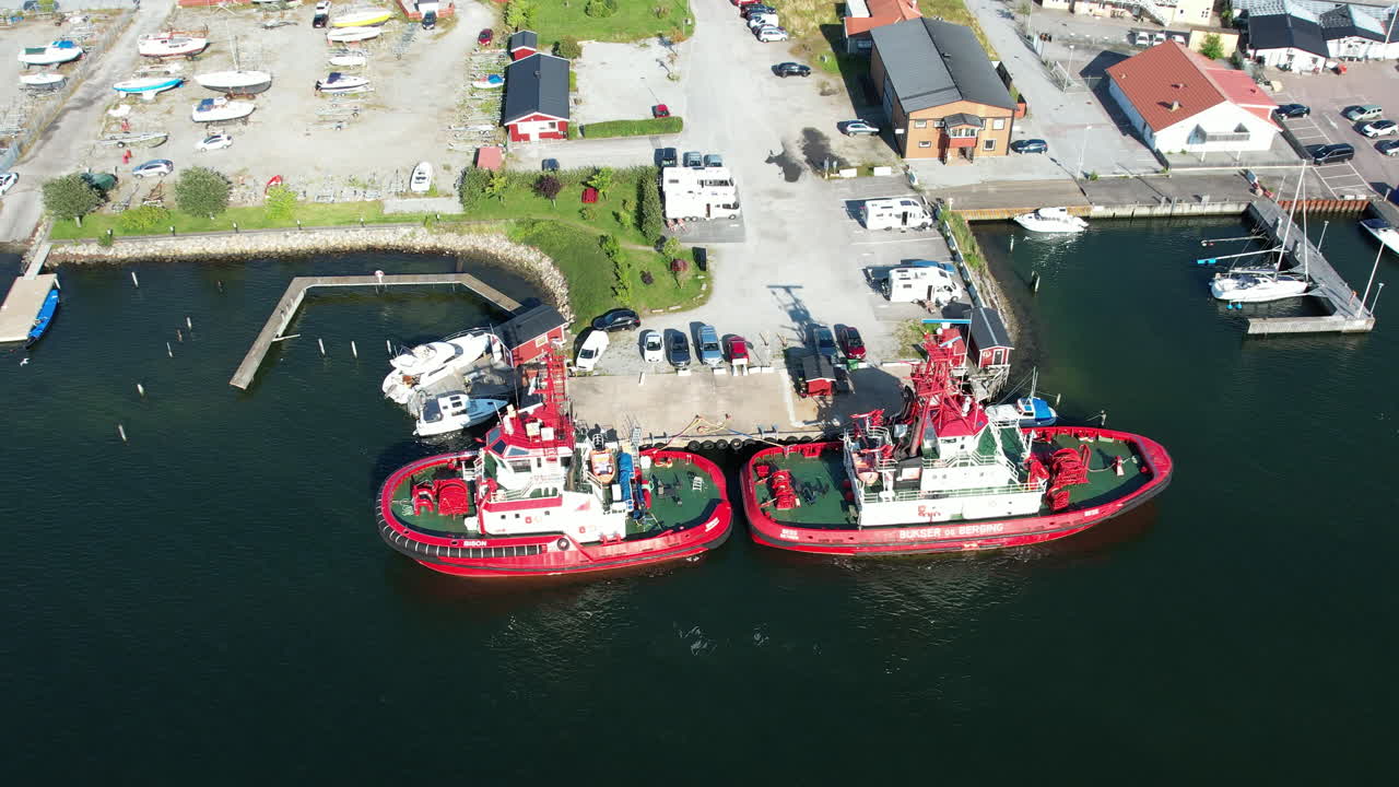 Flyover drone shot of two towboats moored at Stenungsund, Bohuslan, Sweden