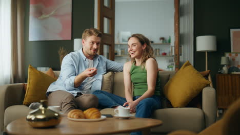 happy pair chatting having breakfast at home. emotional man telling funny story