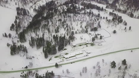 Lange-Grüne-Straße,-Die-Sich-Im-Hochland-Windet-Und-Mit-Weißem-Schnee-Bedeckt-Ist