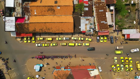 Top-down-drone-shot-over-taxis-and-mototaxis-in-Sao-Tome-city,-sunny-Africa