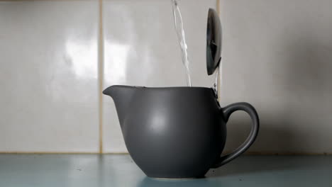 hot water being poured into a modern tea pot