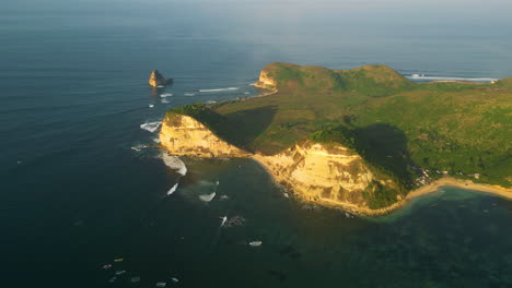 aerial circling cliff at gerupuk surf spot at golden hour, indonesia