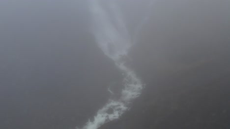 río del valle y cascada detrás de la niebla en islandia