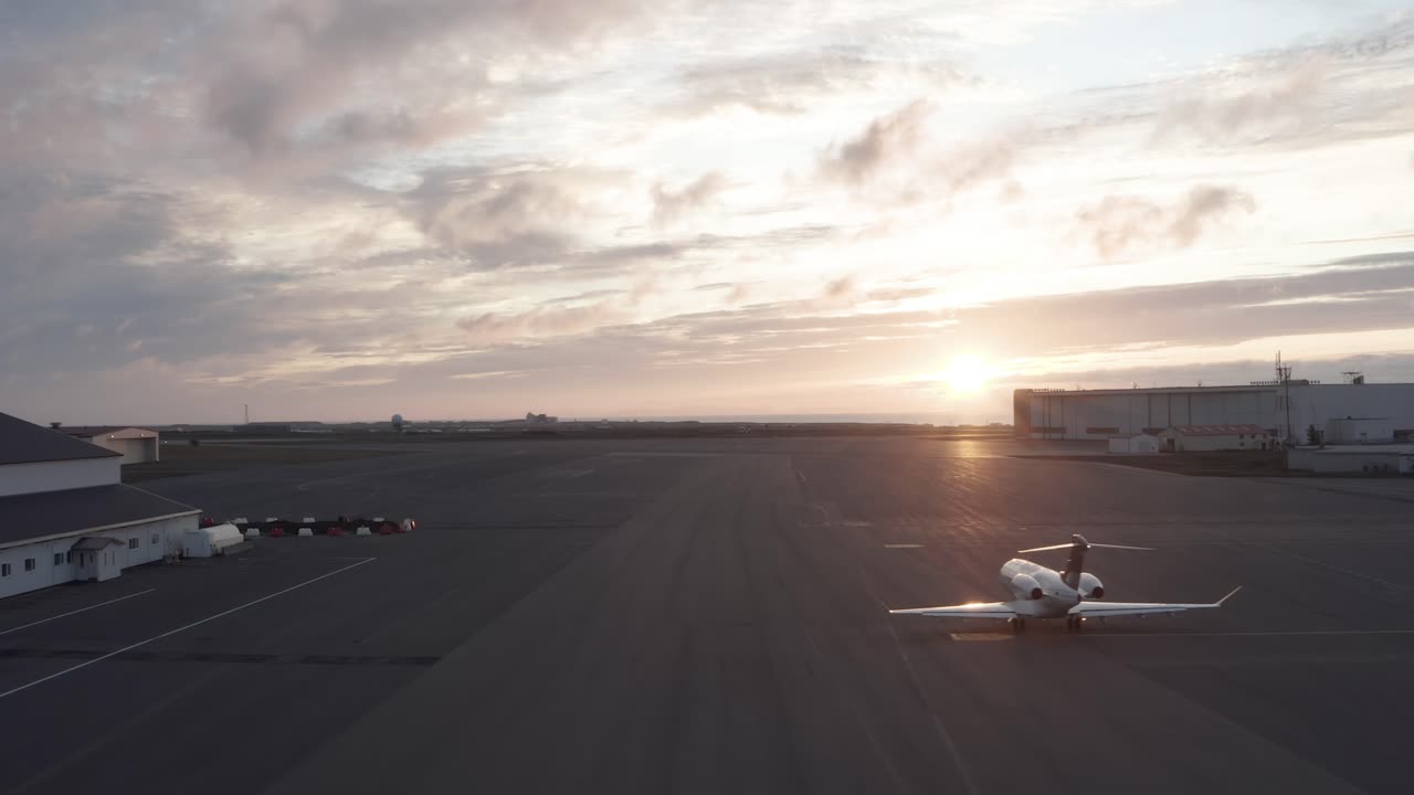 jet privado taxiando hacia la pista en el aeropuerto de islandia durante la puesta de sol perfecta