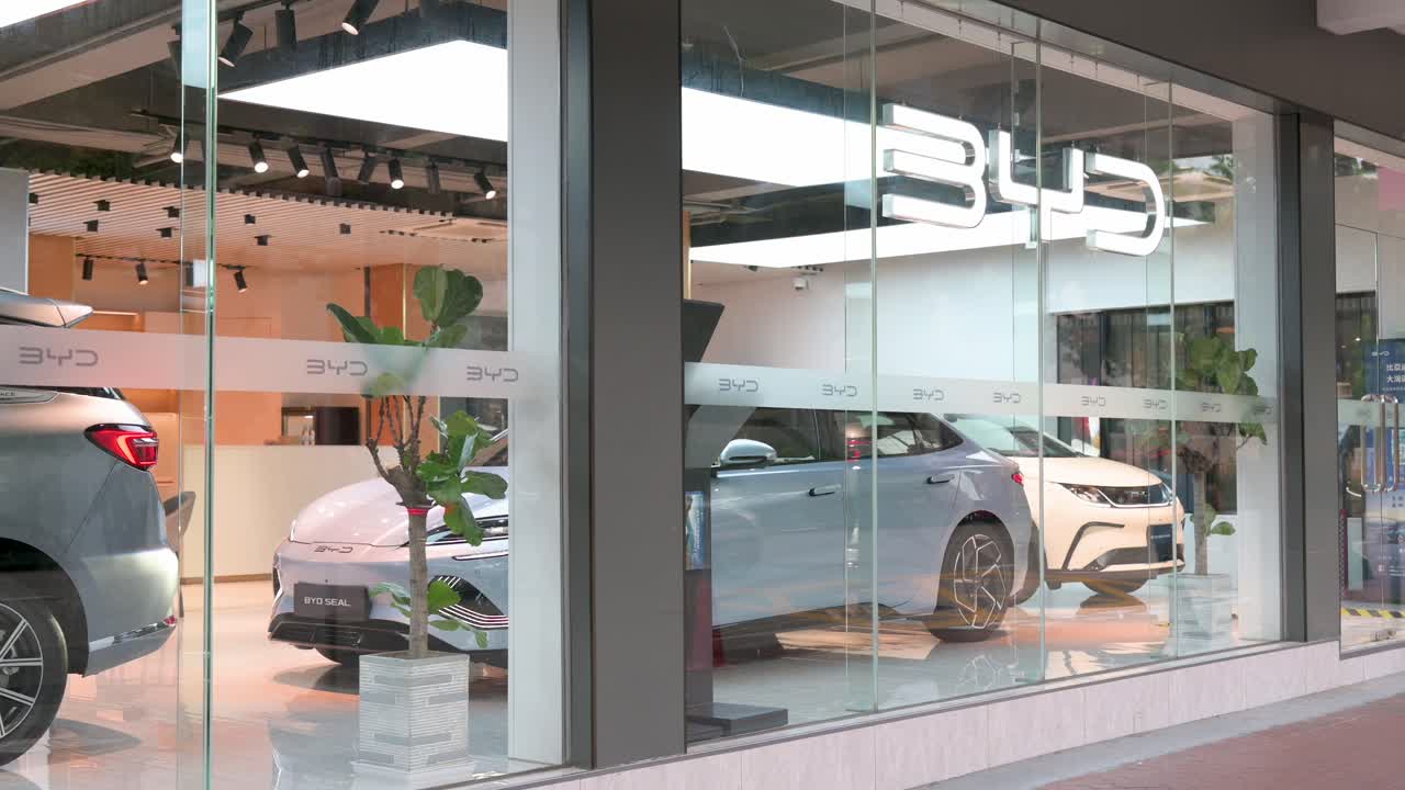 A pedestrian walks past the official authorized dealership of the Chinese automaker BYD.