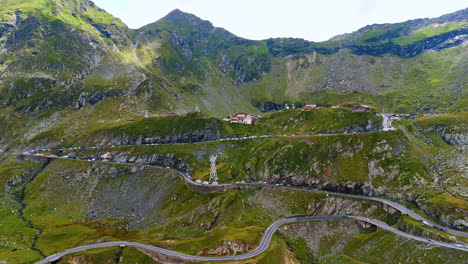 approaching the picturesque slopes of the mountains with a highway. multiple cars stand on the highway. famous transfagarash highway in romania