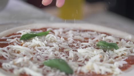 chef adding cheese and olive oil to pizza