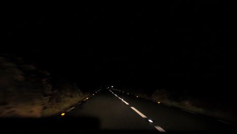 pov driving at night on a rural road with reflective road markings.
