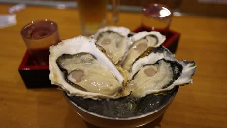 hand squeezing lemon juice onto raw oysters