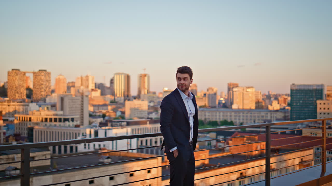 Ambitious entrepreneur standing terrace observing sunset urban view. Man leader