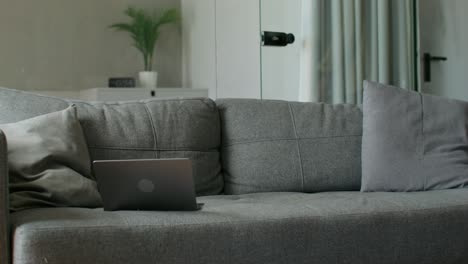 man relaxing on couch, using laptop and phone