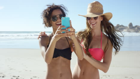 Two-friends-taking-selfies-on-the-beach