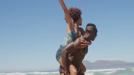 hombre sin camisa dando paseo a una mujer en la playa 4k