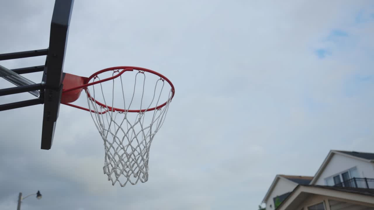 Basketball Ring Under The Dramatic Sky Outside The House - low angle shot