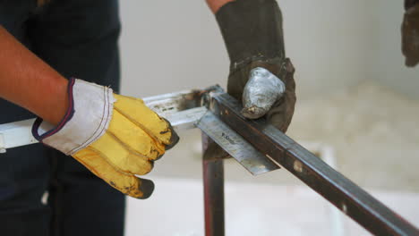hands of a metalworker measuring steel for fabrication with l-shaped angle ruler. close up