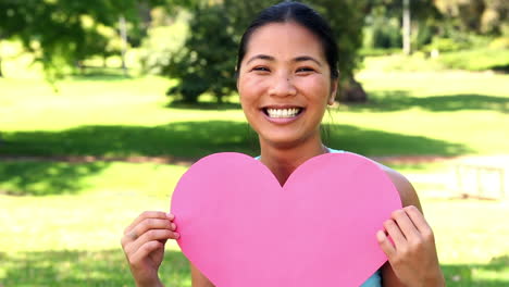 fit asian girl showing an paper heart