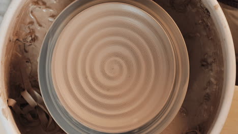 manos moldeando arcilla en una rueda de cerámica