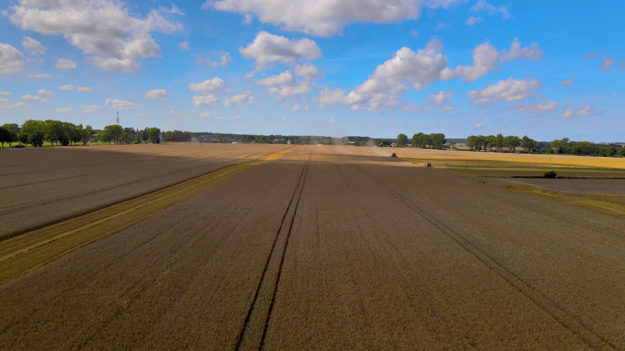 Moderne Mähdrescher arbeiten auf dem Feld und ein wunderschöner blauer Himmel und Wolken in der Nähe von Puck, Polen