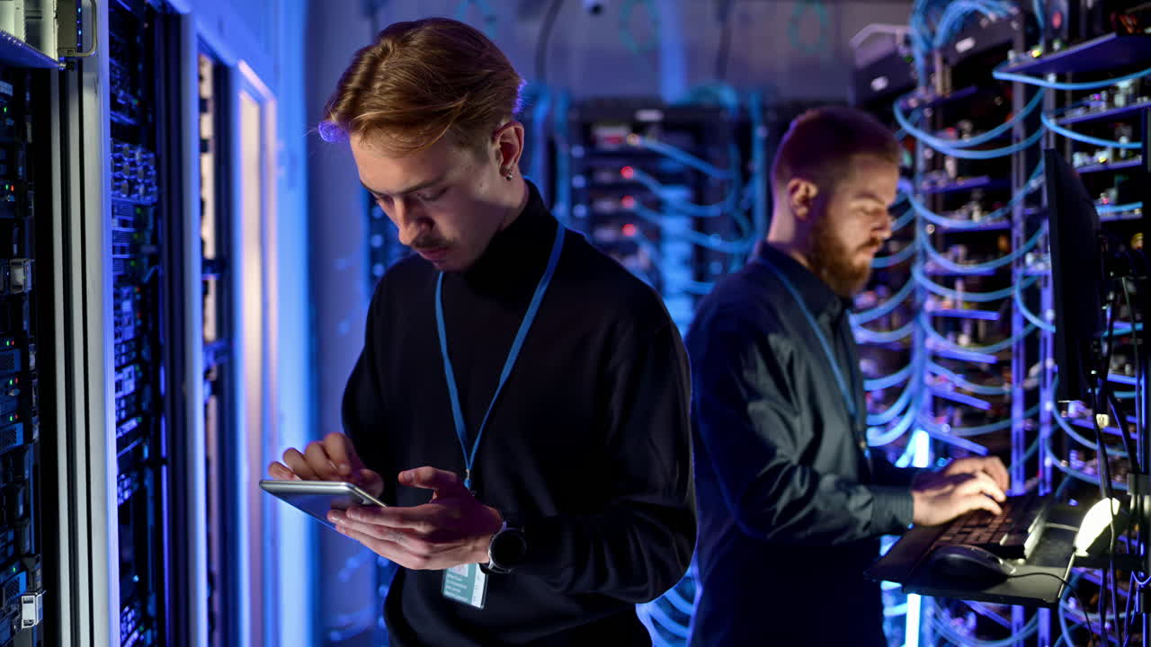 Two men managing data in a server room